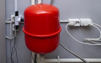 Red expansion tank and pipelines in the boiler room of a private house. High quality photo